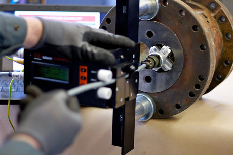Techniker misst den Verschleiß eines Extruder-Gehäuses mit einem digitalen Messsystem und Präzisionssensoren